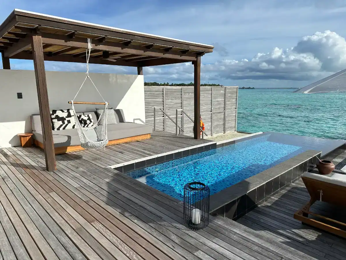 Sirru Fen Fushi Maldives private lagoon resort: Overwater villa with pool, daybed, and ocean view.