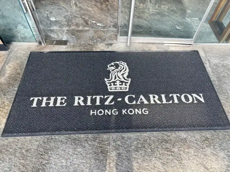 Ritz-Carlton Hong Kong doormat with logo on a gray stone floor.