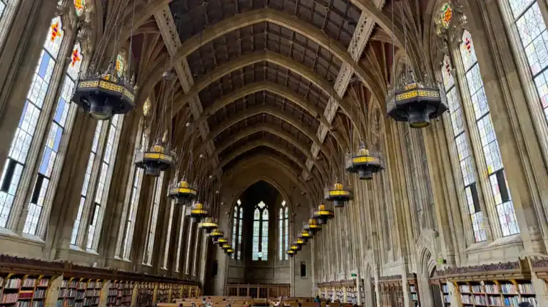 University of Washington Suzzallo Library's grand reading room with arched ceilings and stained glass.